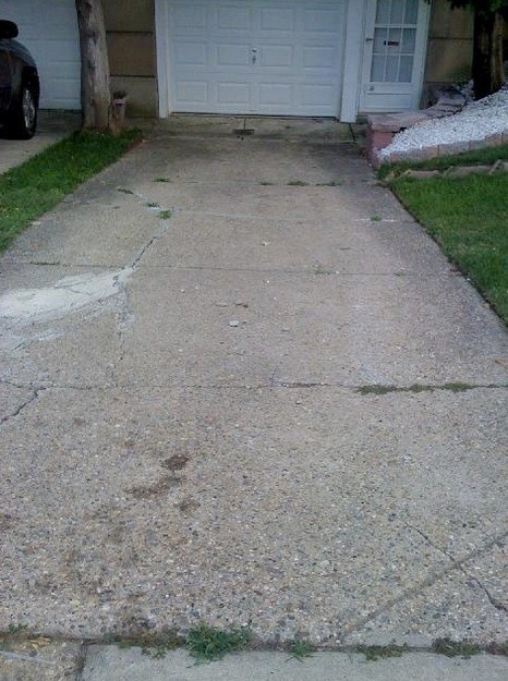 Before: worn, stained driveway ahead of replacement